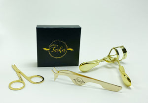 Black and gold lash box, with gold scissors, tweezers and lash curler. 